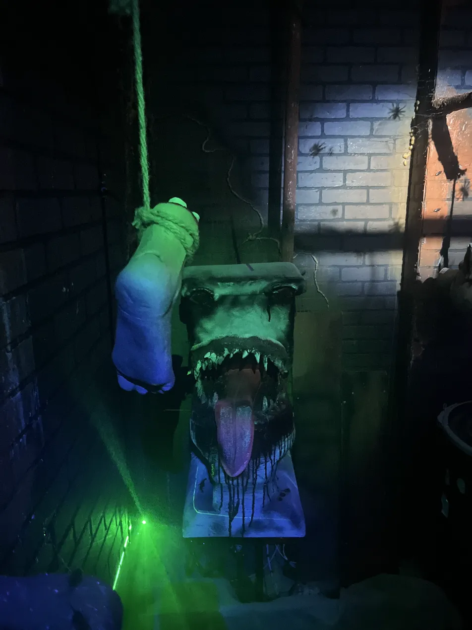 Monster toilet prop with fangs and tongue under green light