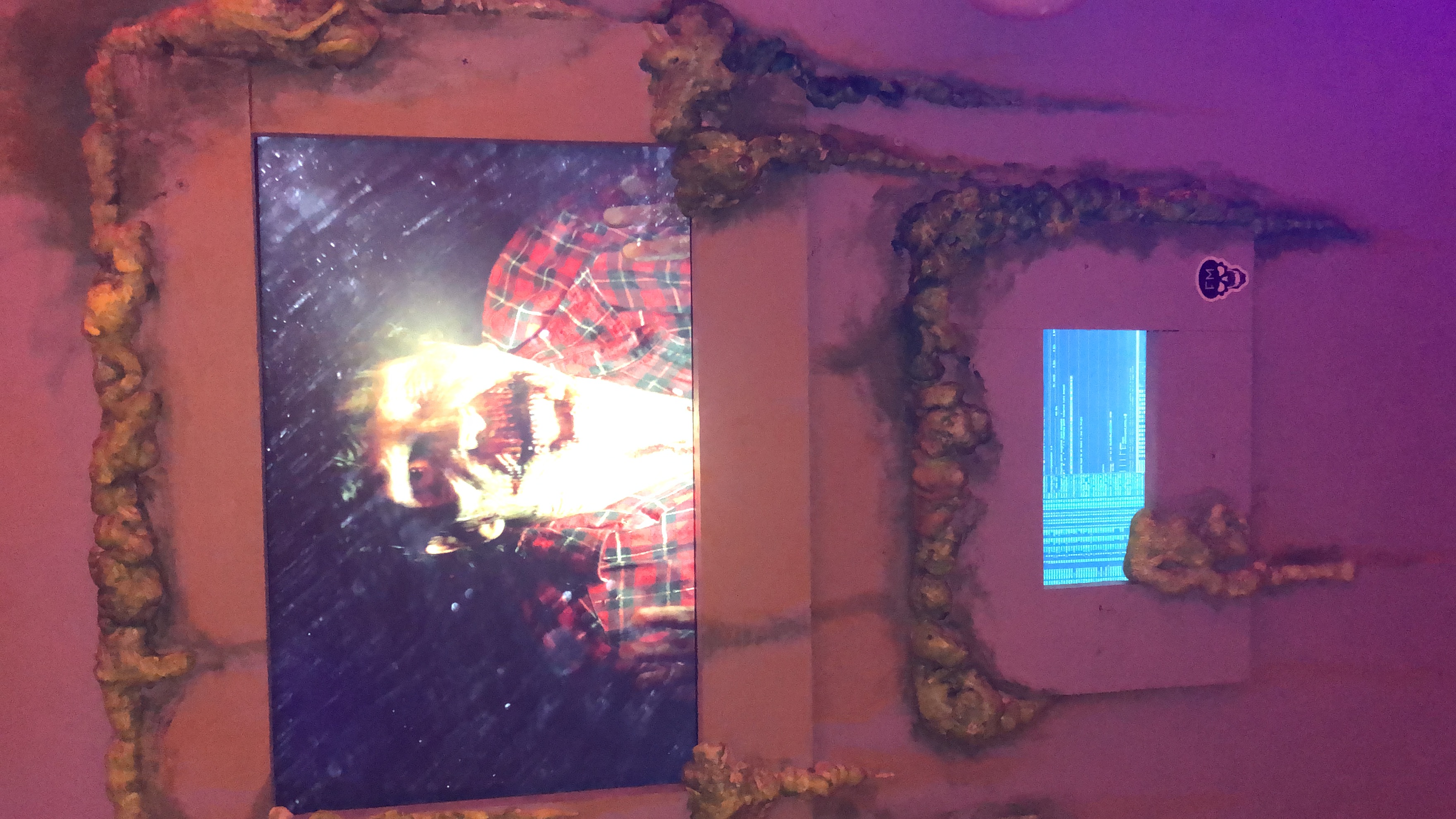 Embedded video screens in a slimed wall showing a zombie broadcast